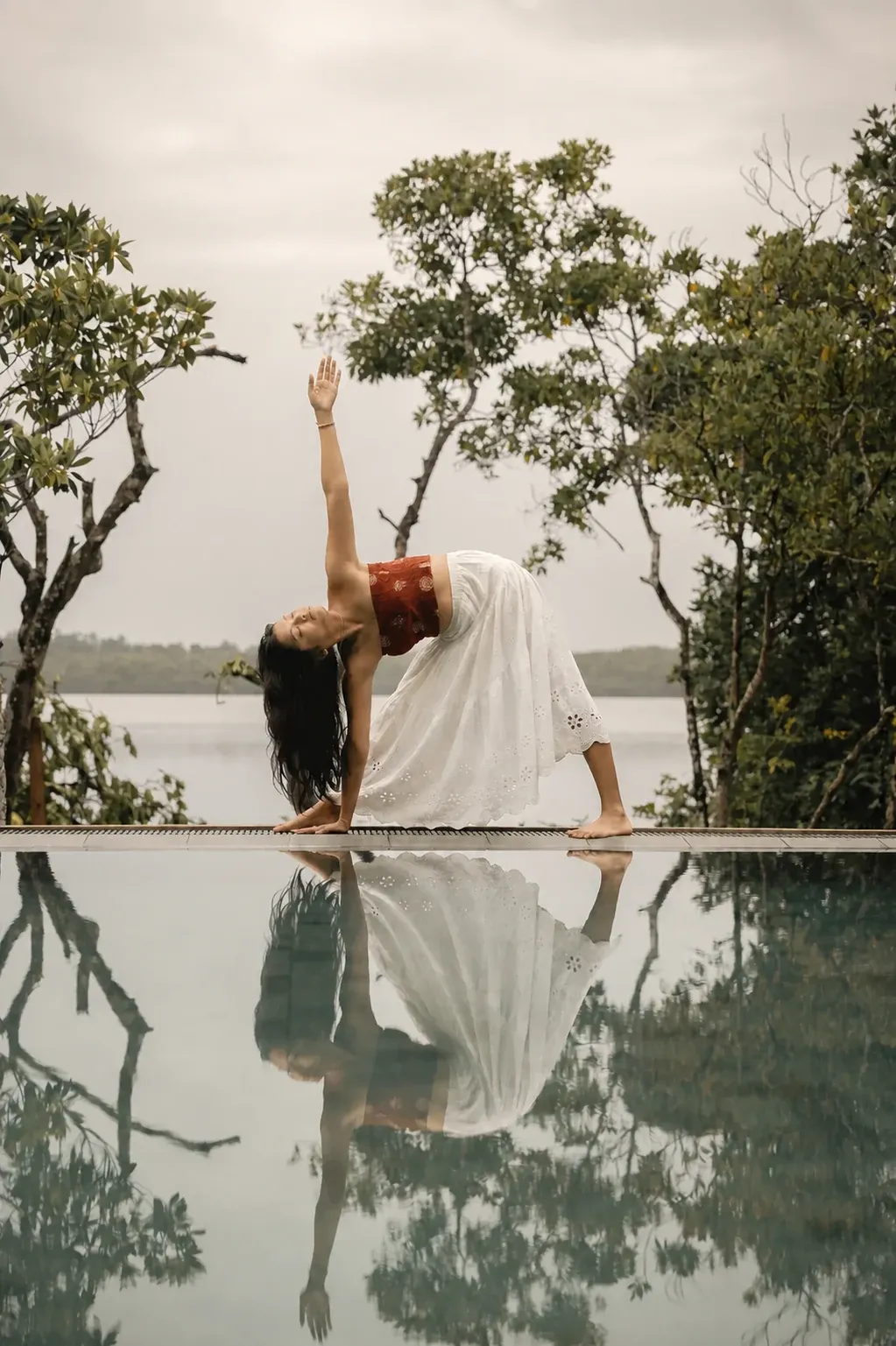 A yoga pose reflected beside the pool