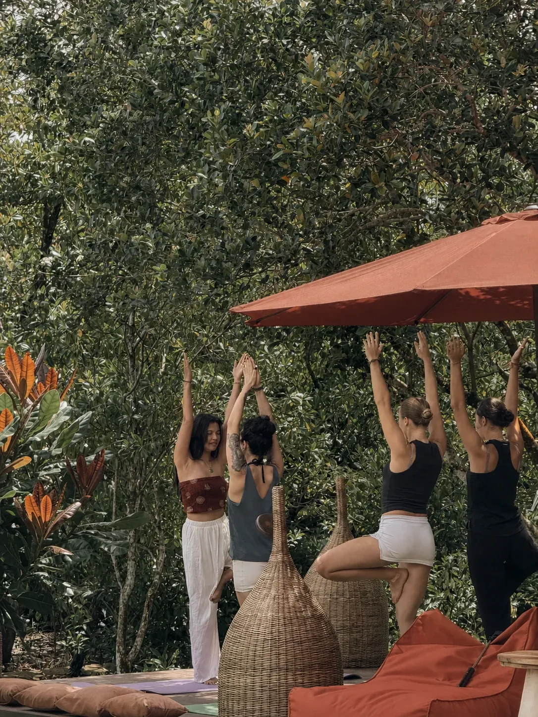 A retreat group practising yoga on the pool deck