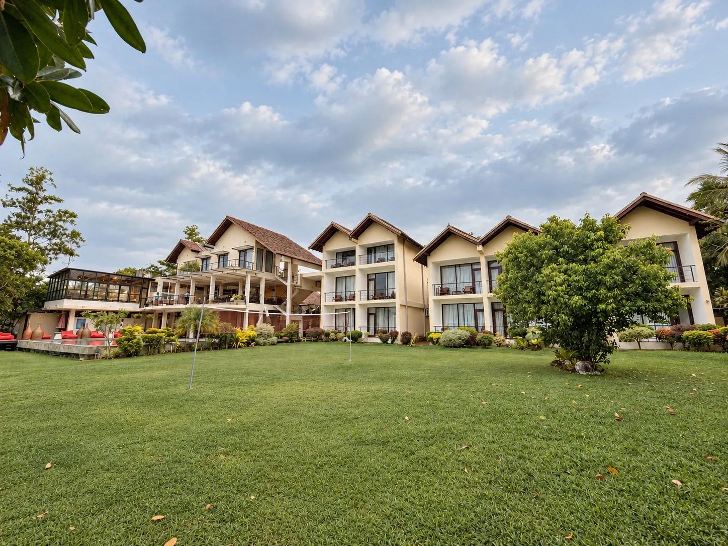 The room blocks behind a wide lawn under a cloudy sky