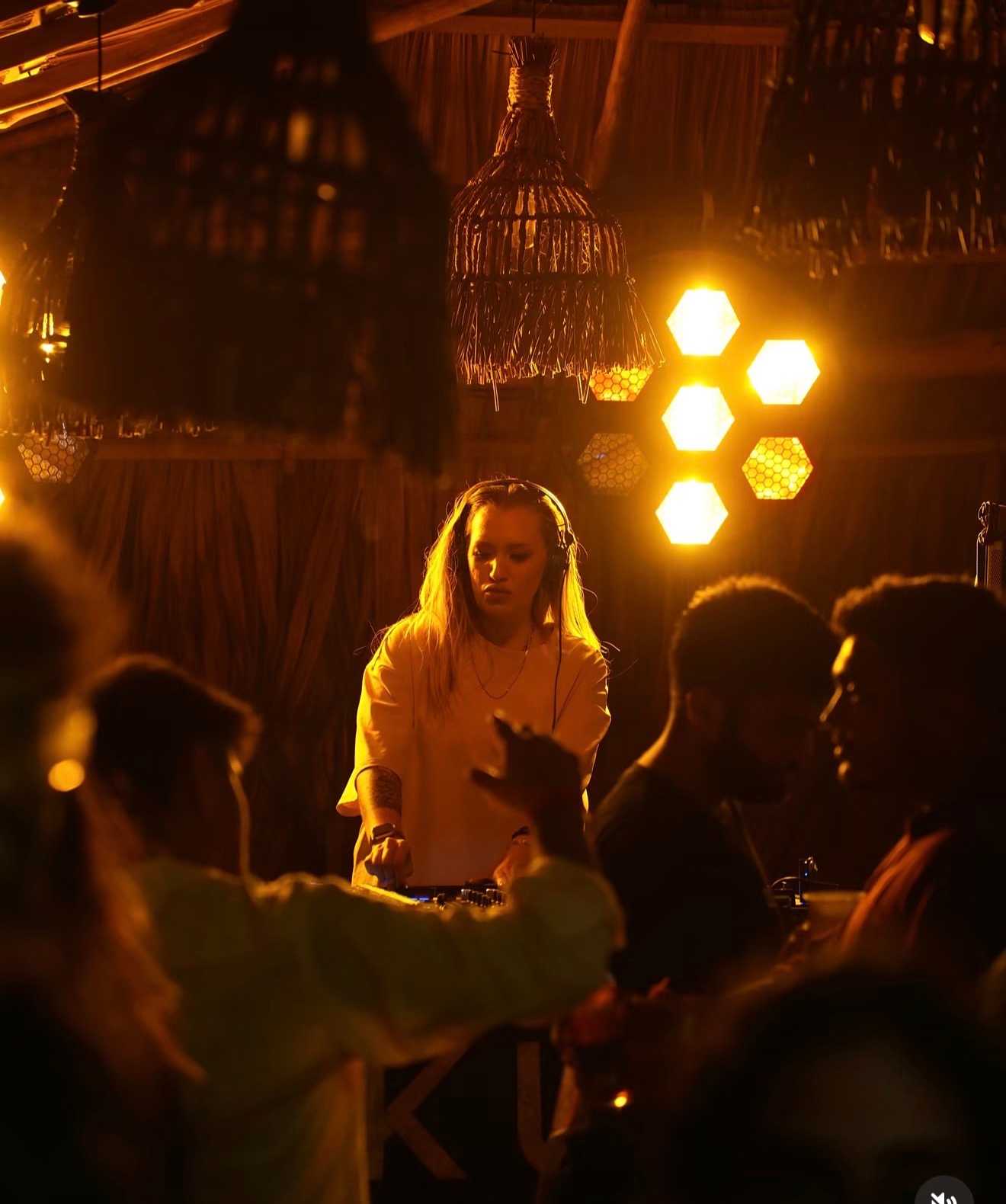 DJ playing under warm lights at a Hakuna Matata party night in Ahangama